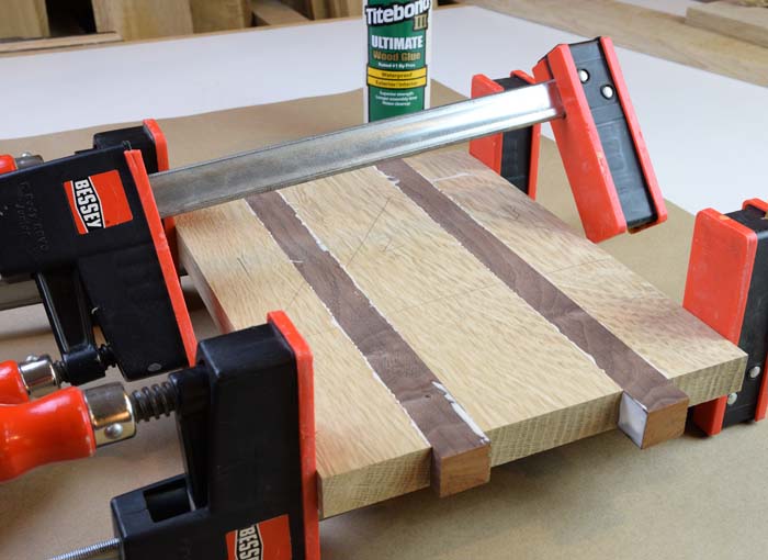 five boards glued up held together with clamps.