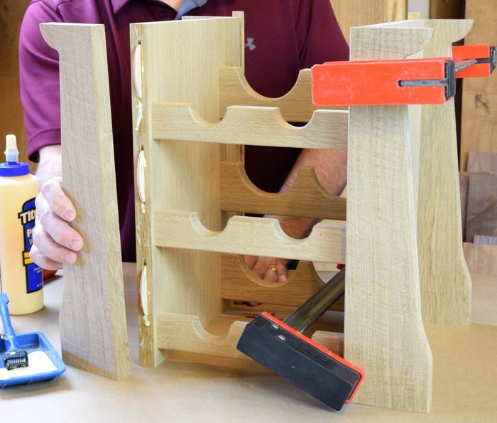 Wooden frame assembly is being glued up with glue covered biscuits and clamps on the right half.