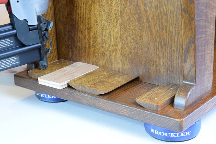 Cabinet upside down and pieces of wood are being nailed in with a brad nailer