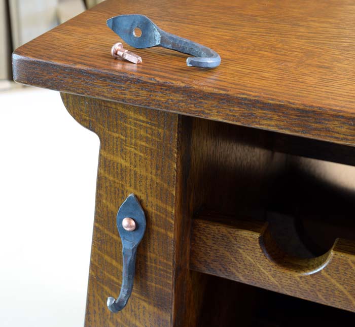 Metal hanger sitting on top of cabinet and one mounted to the front with a copper nail