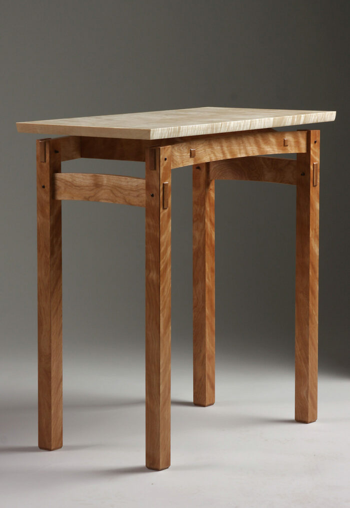 Wooden table with a redish base and a lighter colored top